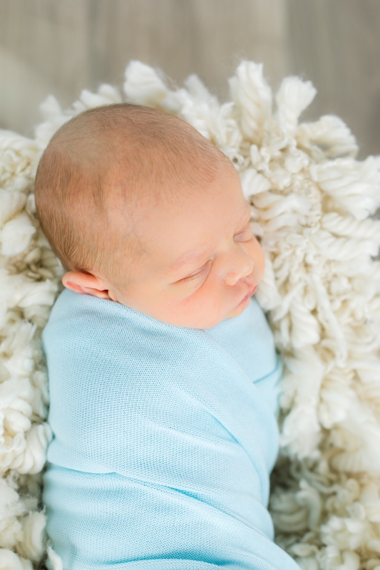 newborn boy in blue wrap