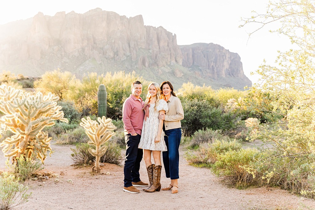 family posing in front of superstition mountain at sunrise