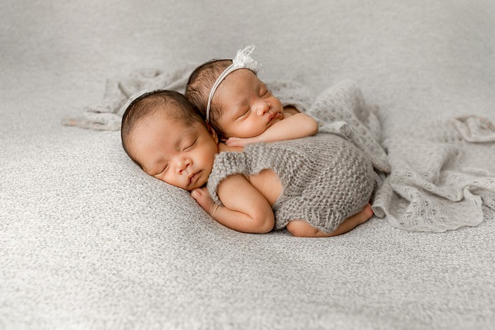 sleeping twin babies laying on each other