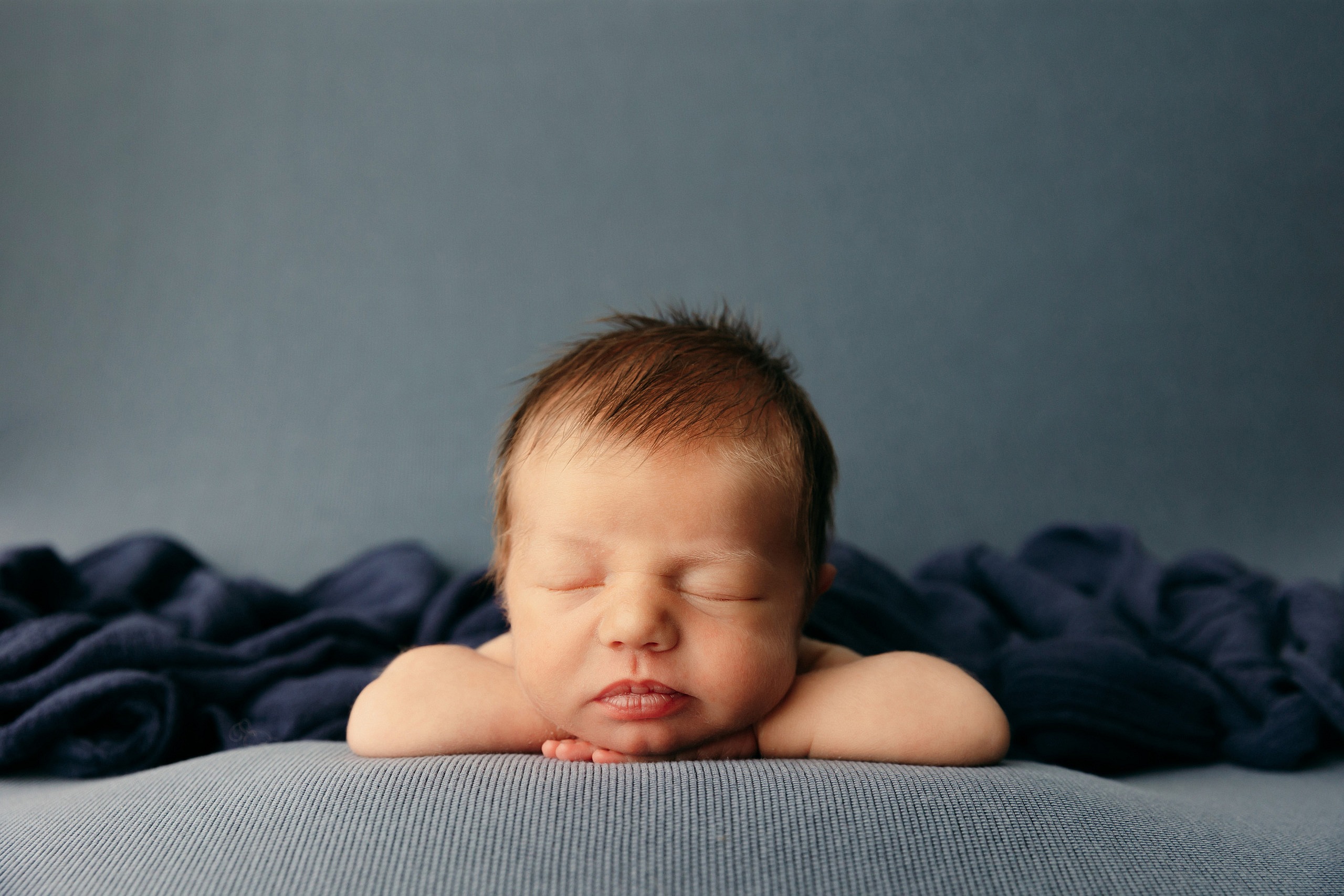 photo-of-newborn-baby-with-chin-on-hands