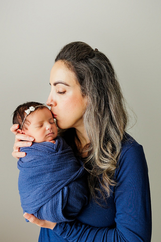 mom kissing her newborn baby girl