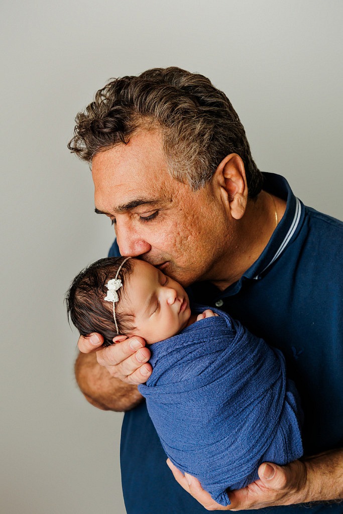 dad kissing newborn baby girl