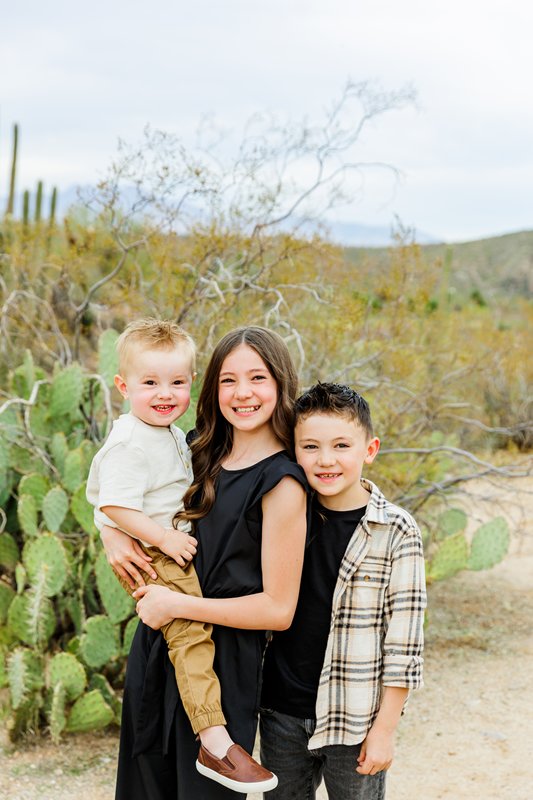 3 kids with cacti behind them