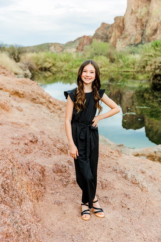 girl posing with mountain reflecting in river water