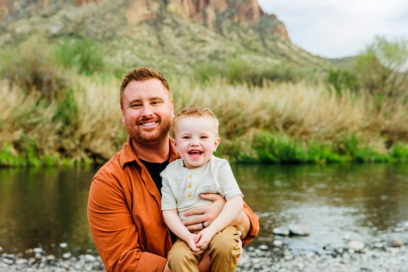 dad holding laughing son at family photo session in arizona